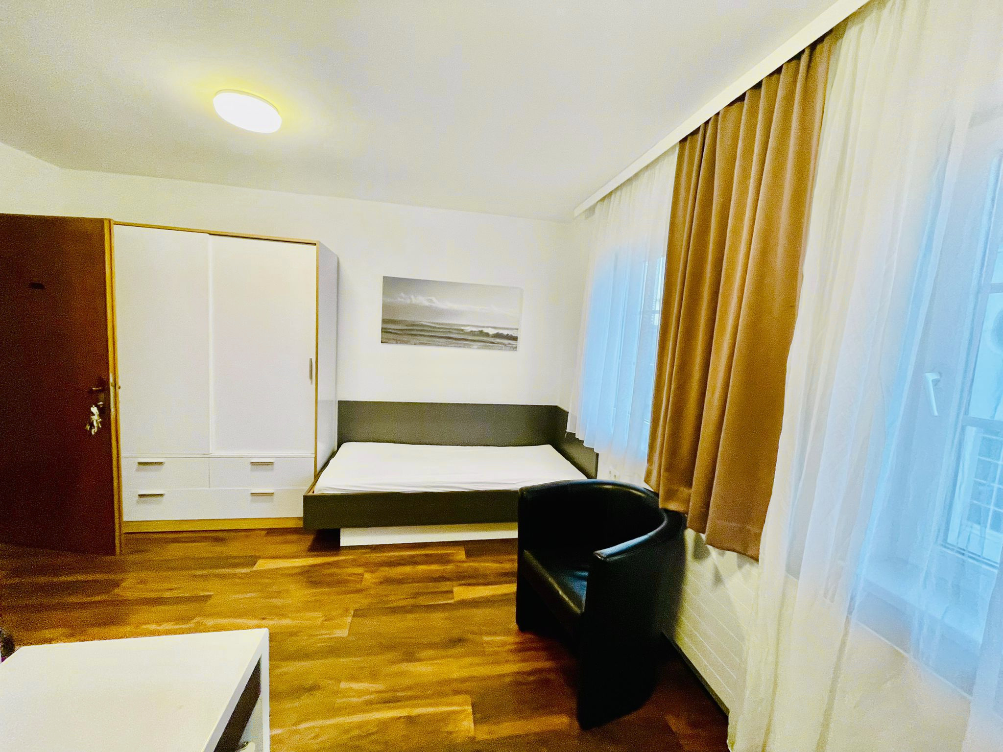 Einzelzimmer mit Schrank und Sitzplatz